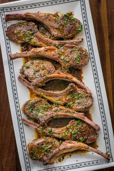 some meat is on a white plate and garnished with parsley