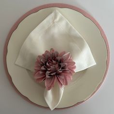 a white plate topped with a pink flower