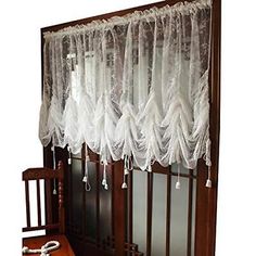 an old fashioned window with white lace curtains