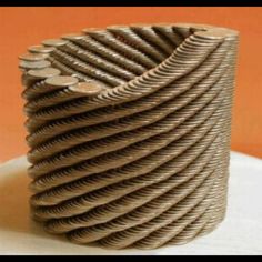 a stack of wooden discs sitting on top of a white table next to an orange wall