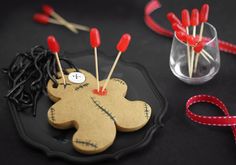 a black tray topped with wooden pins and a teddy bear pincuss on top of it