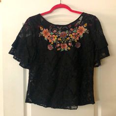 Darling Boutique Blu Pepper Black Lace Floral Embroidery Top Size Small S Grosgrain Ribbon Tie In Back Flutter Double Lace Sleeves 70% Cotton 30% Nylon Measure Armpit To Armpit 18 Inches Neckline To Hem 20 Inches Gorgeous Versatile Top Embroidered Short Sleeve Lace Blouse, Short Sleeve Embroidered Lace Blouse, Embroidered Lace Blouse With Short Sleeves, Elegant Black Blouse With Intricate Embroidery, Elegant Floral Embroidered Top, Floral Embroidery Lace Top With Short Sleeves, Black Top With Intricate Embroidery, Elegant Short Sleeve Lace Top With Floral Embroidery, Elegant Black Tops With Floral Embroidery