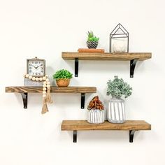 three wooden shelves with pots and plants on them