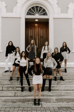 a group of young women standing on steps in front of a building