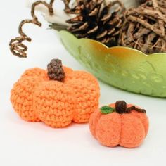 two crocheted pumpkins sitting next to each other