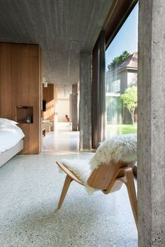 a bedroom with concrete walls and white carpet