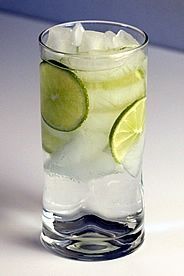 a glass filled with ice and lime slices