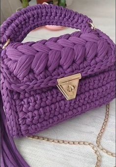 a purple purse sitting on top of a white table