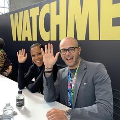 two people sitting at a table with their hands up in front of them and the words watch me above them