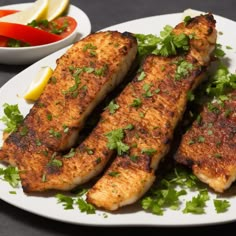 three fish fillets on a plate with garnishes