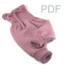 a pink knitted sweater with ruffles on the sleeves and bottom is shown