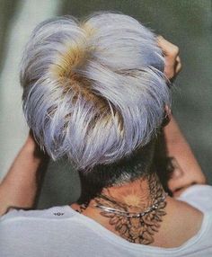 the back of a woman's head with grey hair and tattoos on her neck