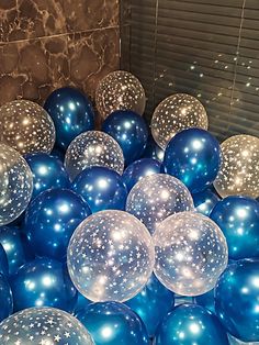 blue and silver balloons are in a ball pit with white stars on the top one