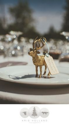 a deer figurine on a plate with a tag in it's mouth