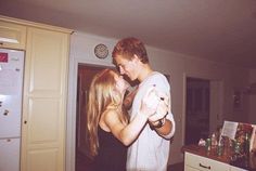 a man and woman standing in a kitchen with the words dancing round the kitchen in the refrigerator