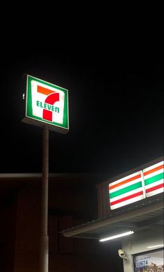 a seven eleven gas station sign in front of a 7 - eleven store at night