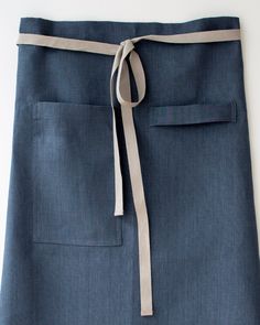 a woman's blue skirt with a tie on the waist and side pockets, tied up