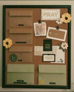 a bulletin board with flowers and other items attached to the wall in front of it