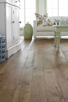 a living room with wood floors and white furniture