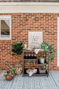 a brick wall with potted plants and other items on the ground next to it