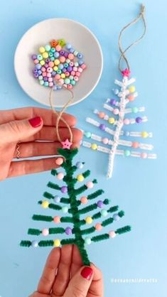 two hands are decorating a small christmas tree with candy and beaded beads on it