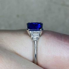 A geometric engagement ring featuring a 1.68 carat emerald-cut natural sapphire, set in prongs and displaying a deep blue color. A graduating design of baguette cut diamonds sits on either side of the center stone. The total diamond weight is 0.24 carats, H color and VS2 clarity overall. This ring is handcrafted in platinum.
The dimensions of the center stone are approximately 6.63mm x 6.08mm x 3.80mm.
This ring can be resized to any finger size at no extra cost.
Ready to Make It Yours? Contact Timeless Radiant Cut Sapphire Ring, Luxury Lab-created Sapphire Ring With Baguette Cut, Luxury Baguette Cut Lab-created Sapphire Ring, Luxury Lab-created Sapphire Baguette Cut Ring, Luxury Asscher Cut Sapphire Ring, Art Deco Blue Asscher Cut Ring, Timeless Blue Radiant Cut Sapphire Ring, Luxury Radiant Cut Lab-created Sapphire Ring, Luxury Emerald Cut Sapphire Ring