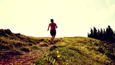 a man running up a hill with trees in the background