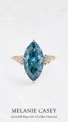 a blue diamond ring with two diamonds on top and the words melanie casey above it