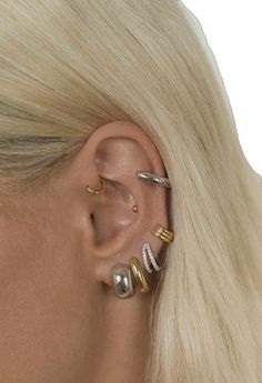 a woman with blonde hair wearing three different ear piercings