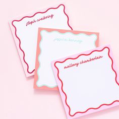 two personalized notepads sitting next to each other on top of a pink surface