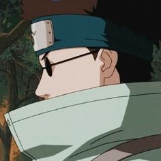 a man with glasses and a headband on staring at something in the distance while standing next to trees