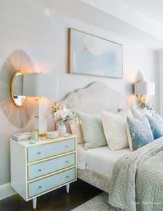 a white bed sitting in a bedroom next to a dresser