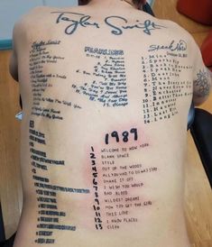 the back of a man's tattoo with numbers and dates written on it in blue ink