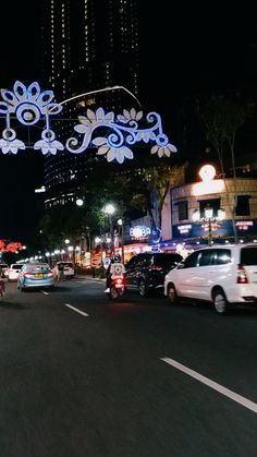 cars driving down the street at night with decorations on it's headlamps