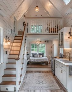 the interior of a tiny house with stairs leading up to the bedroom and living room