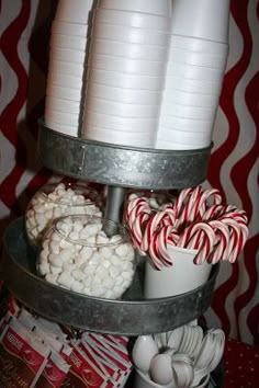 a three tiered tray with candy canes and marshmallows