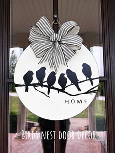 a door hanger with birds sitting on a branch in front of a glass window