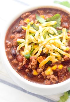 a white bowl filled with chili and cheese