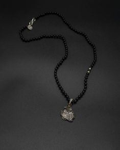 Add a touch of cosmic beauty to your collection with this Campo del Cielo meteorite pendant on a hand-knotted onyx and silver accented chain. The onyx chain is 59 cm long [app 23 in long] Black Sterling Silver Necklace, Luxury Black Necklace With Polished Beads, Onyx Necklace With Large Pendant For Gift, Black Sterling Silver Medallion Jewelry, Black Oxidized Pendant Necklaces, Black Medallion With Large Pendant, Black Amulet Necklace With Natural Stones, Spiritual Black Jewelry With Large Pendant, Silver Onyx Necklace With Black Beads