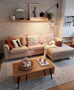 a living room filled with furniture and a brick wall behind the couch is a coffee table