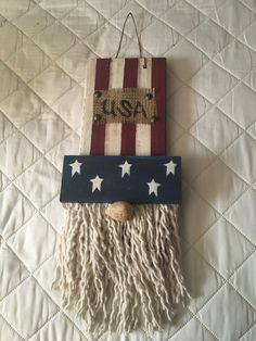 an american flag wall hanging with fringes and stars on the bottom is made from wood