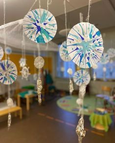 an image of a classroom setting with wind chimes hanging from the ceiling and tables in the background