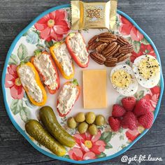 an assortment of food on a plate with nuts, crackers, cheese and fruit