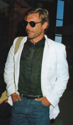 a man wearing sunglasses and a white jacket