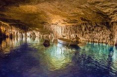 a boat floating in the middle of a cave filled with water