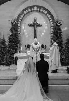 the bride and groom are sitting at the alter in front of the altar with their priest