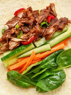 an assortment of vegetables and meat on a tortilla