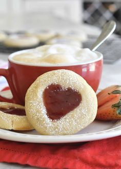 a plate with some cookies on it and strawberry jam in the bowl next to them