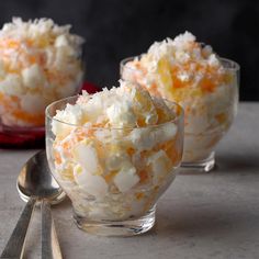 three small glass bowls filled with food on top of a table next to spoons