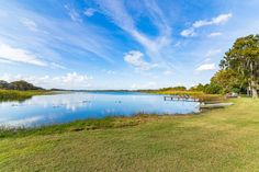 a lake surrounded by lush green grass and trees